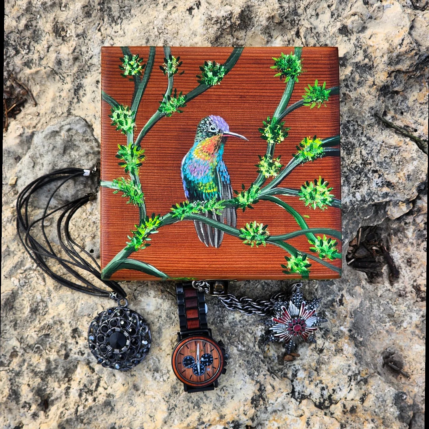Antique wooden trinket/jewelry box, handpainted with acrylic paint inspired by nature and the beauty and colorful harmony of the hummingbirds. Metal feet and lock was added to the box to make it look more professional and complete as a work of art. It includes felt inside to insert rings in it.