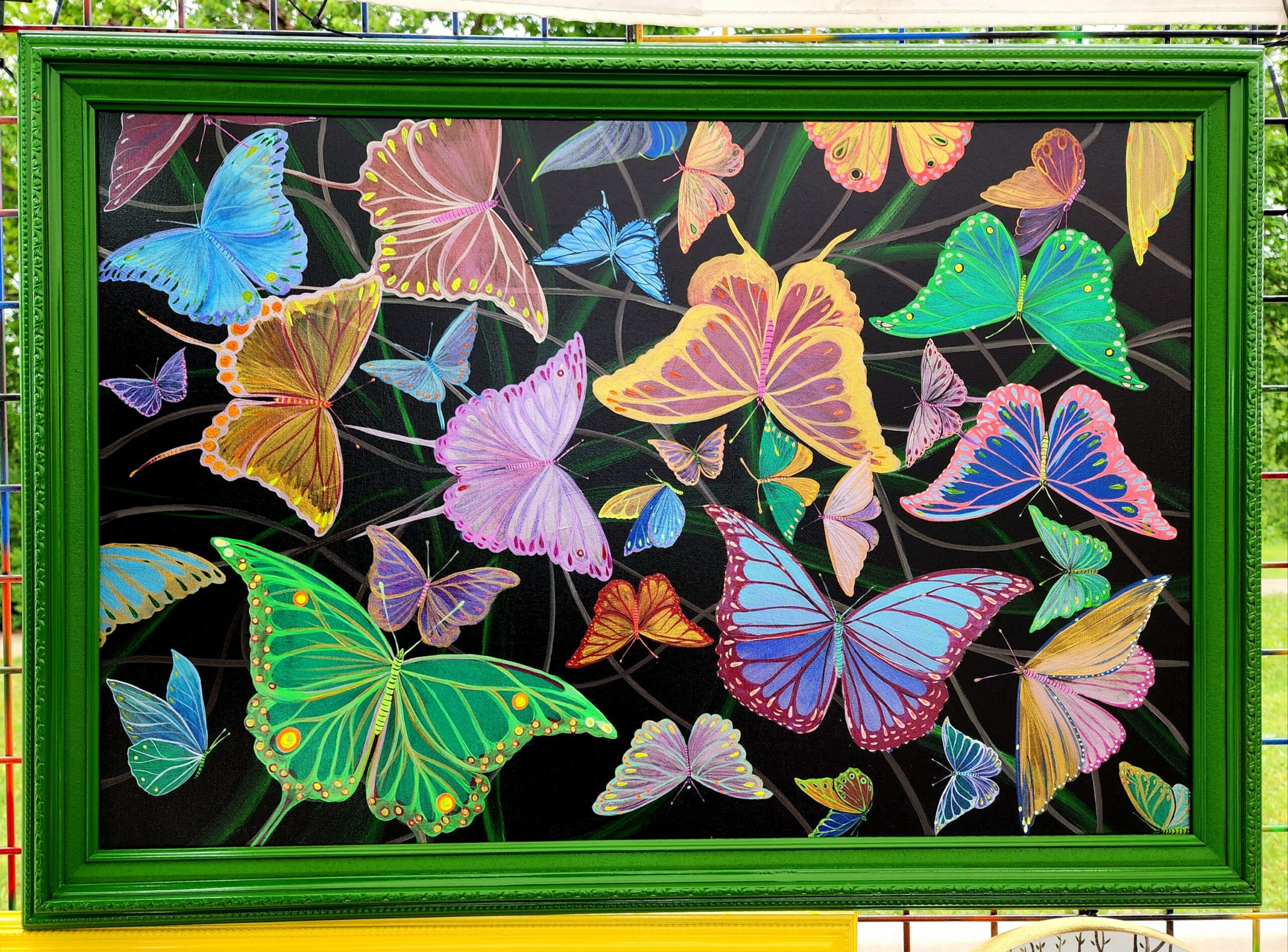 This is a fluorescent painting of butterflies flattering between vines throughout the darkness that glows with black light or UV light. Painted wooden frame. Painting size: 24"x36"