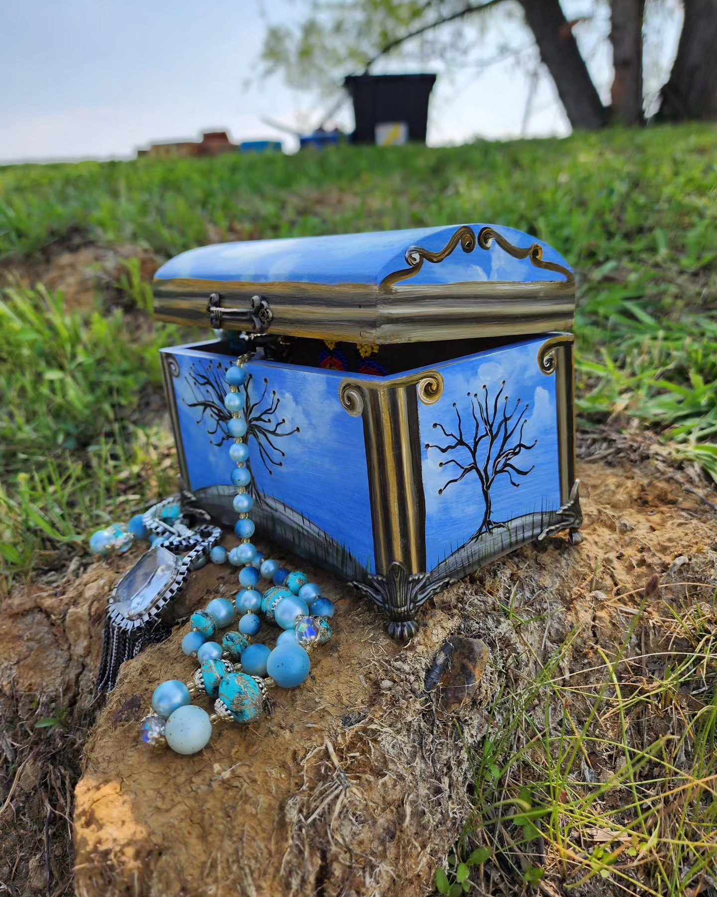 Handpainted Wooden Jewelry Box with original design of the Ancient Greek Temple. The idea was to create a simulation of the temple wrapping around the box with a nice blue sky. This box has metal feet, bronze handle, and blue insert ring.