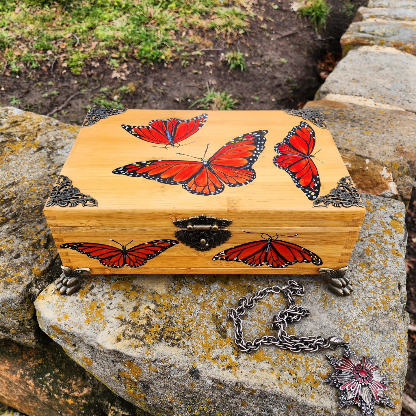 Antique bamboo box repurposed into a trinket/jewelry box with design of some monarch butterflies. Bronze plated clasps and corner decorations added with brass feet.