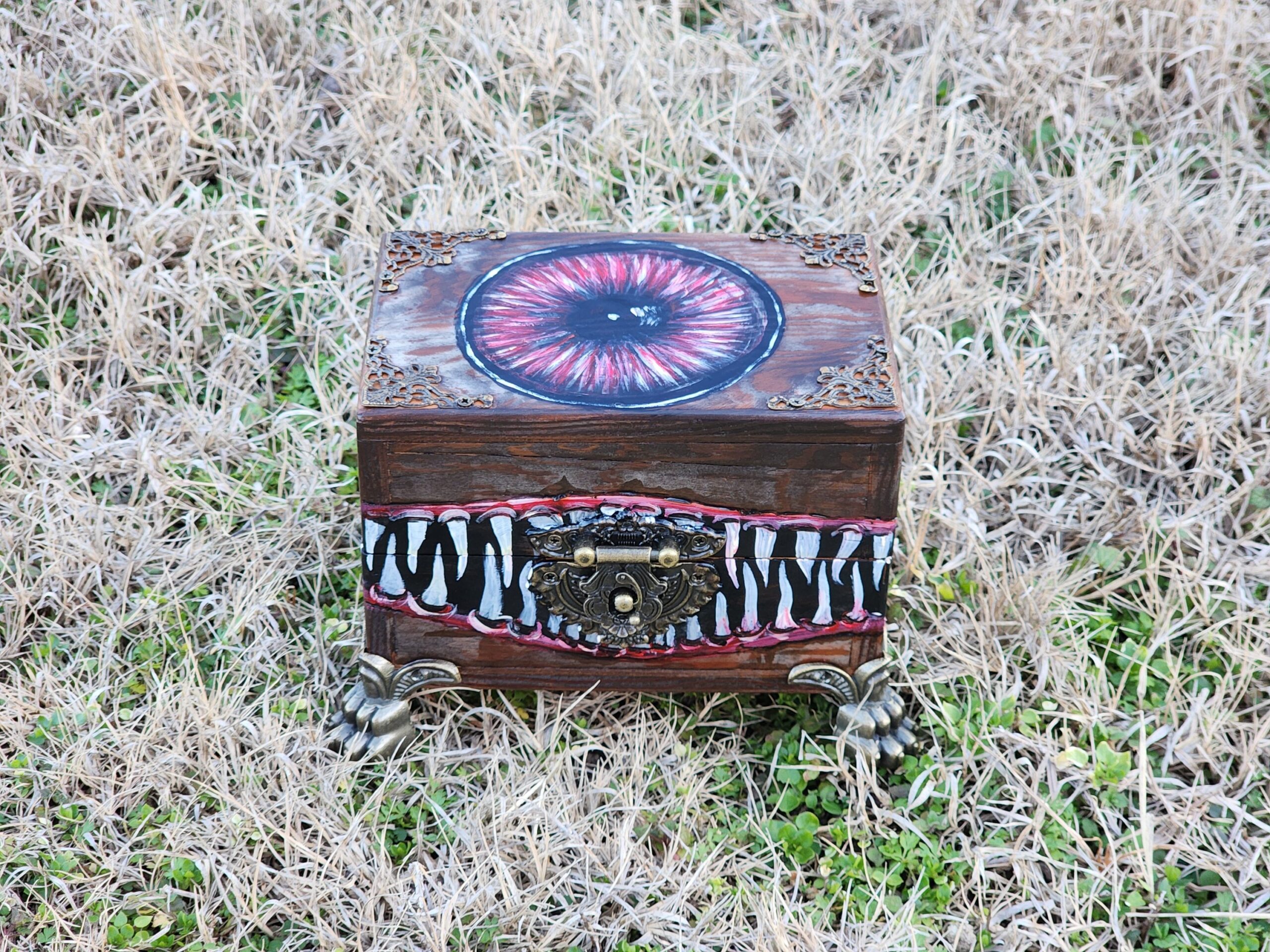 Repurposed wooden trinket box into a jewelry box with the design of a monster. Brass feet, antique bronze plated clasps, and corner decorations.