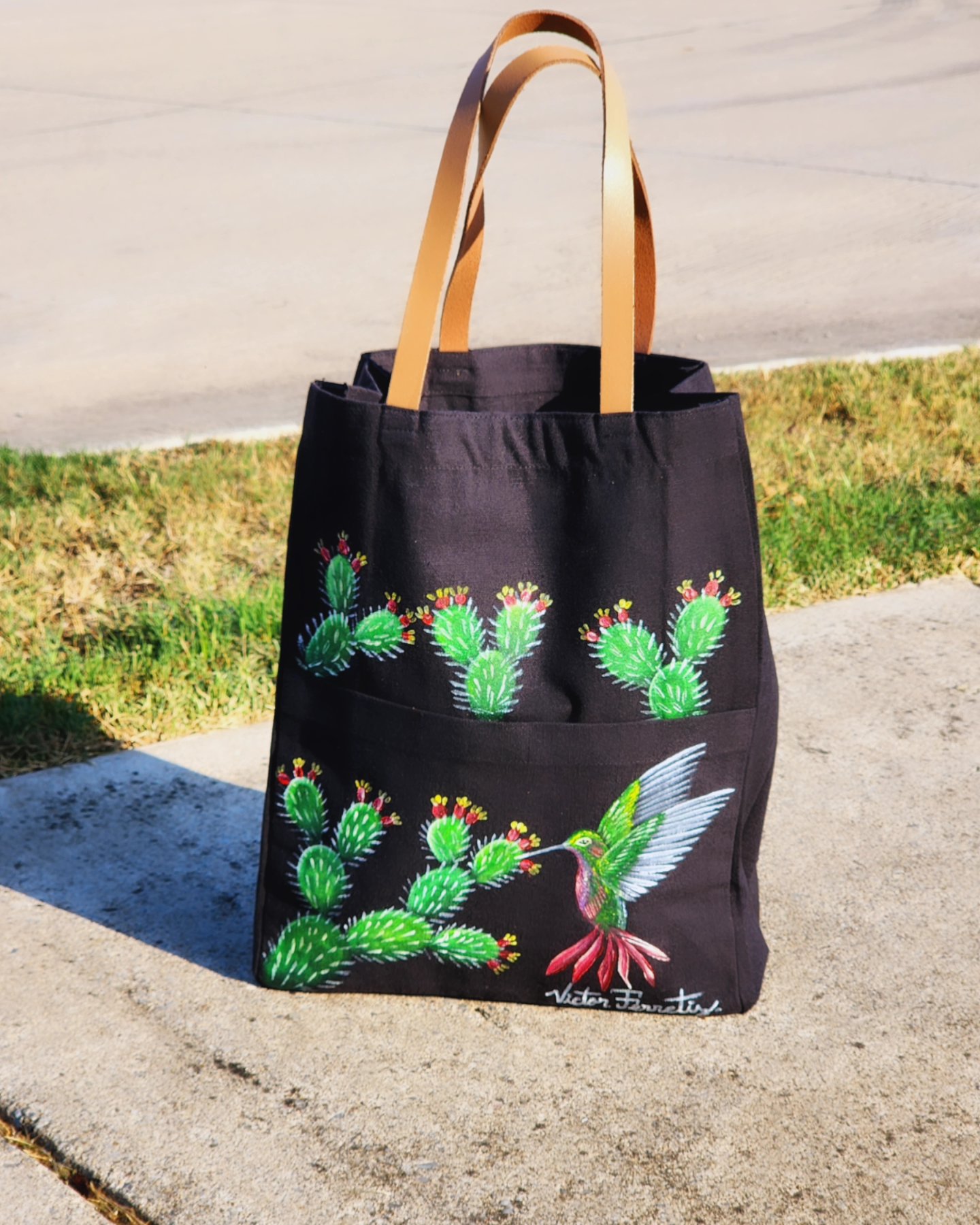 This is a handpainted black tote bag with resistant leather handles. This bag was painted with textile paint on tote fabric. Size: 12x15 inches. Washer and dryer safe.