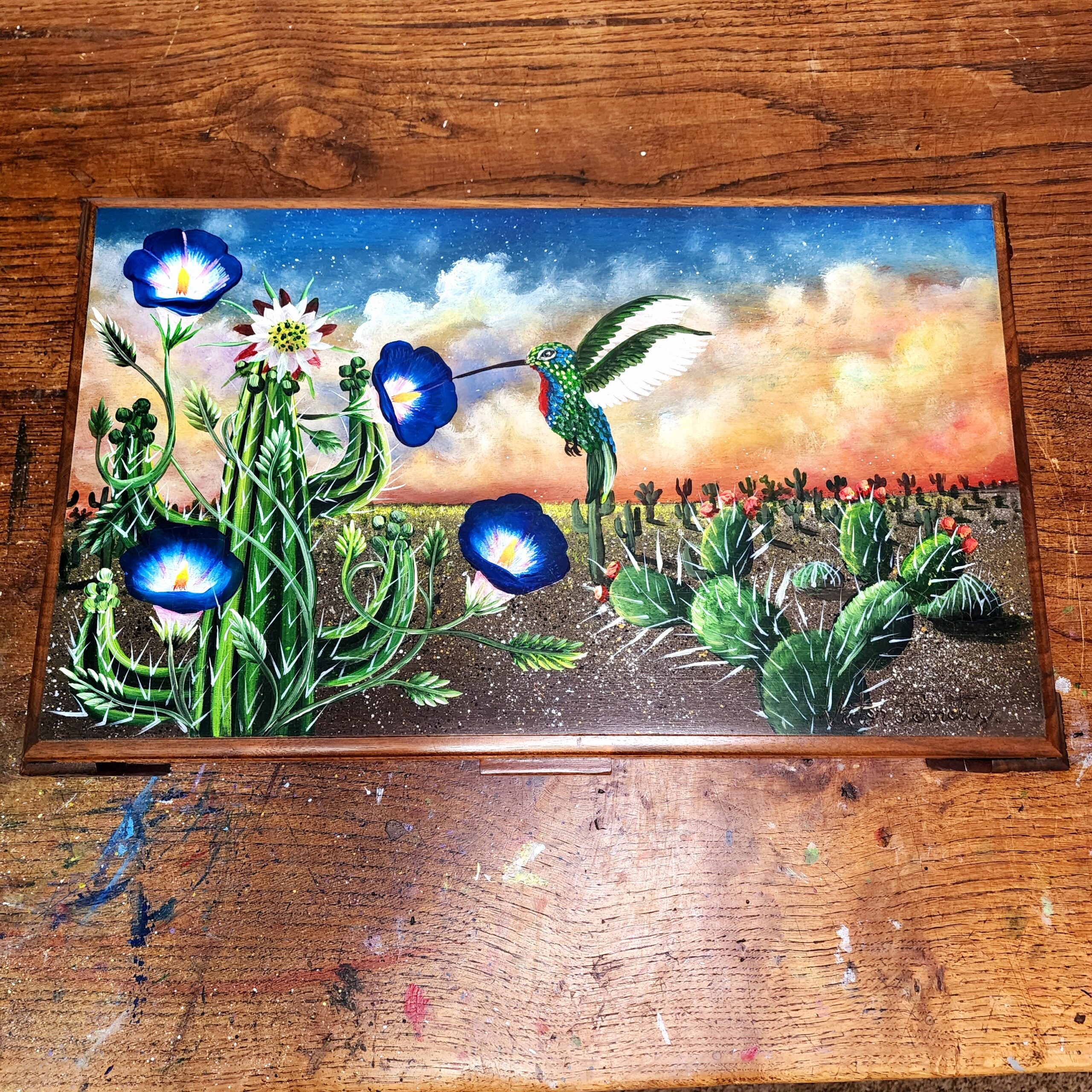 Repurposed antique wooden jewelry box with original design of cacti landscape and hummingbird.