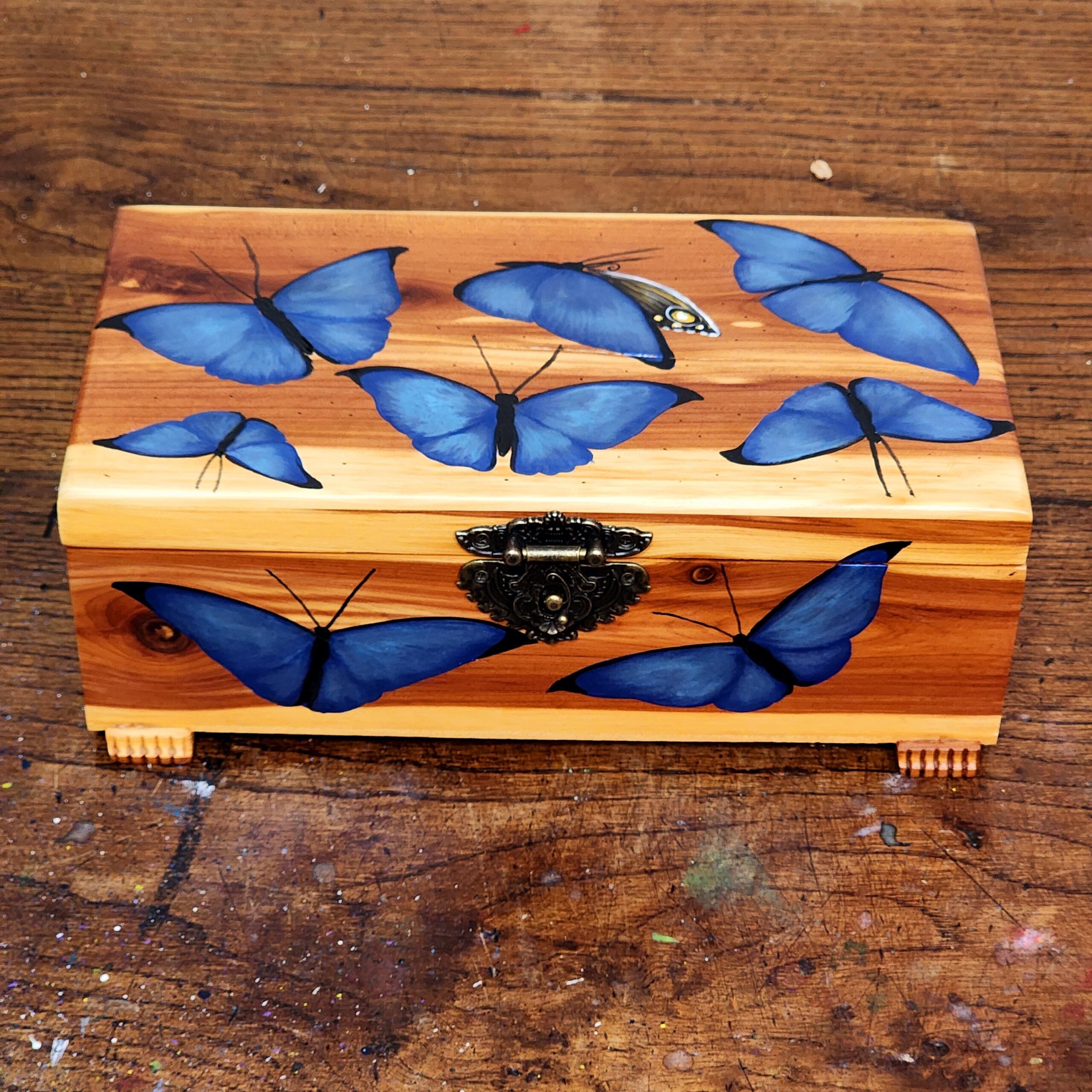 Repurposed antique wooden jewelry box with original design of blue morpho butterflies.